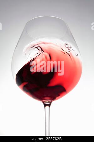 Rotwein erzeugt eine Welle im Glas Stockfoto