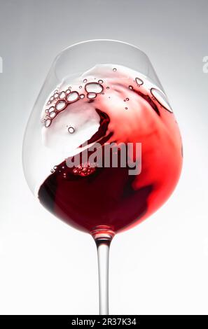 Rotwein erzeugt eine Welle im Glas Stockfoto