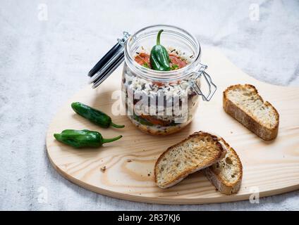 Reis, Tomatensoße, gebratene Paprika, Sojamleisch, Kidney Beans und Linsen in einem Glasgefäß, serviert mit getoastetem Brot Stockfoto