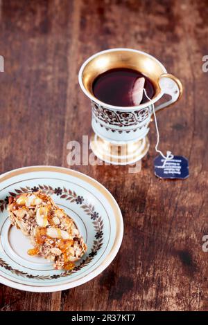 Müsliriegel mit Erdnüssen und gesalzen Karamell, mit einer Tasse Tee Stockfoto