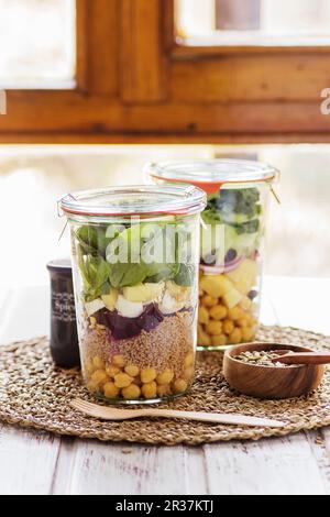 Zwei Salate in Töpfen in ein Buffet für einen Brunch mit einer Mischung von Saatgut für Dressing vorbereitet Stockfoto