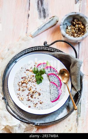 Eine Smoothie-Schüssel mit Joghurt, Chiasamen, Drachenfrucht und gerösteten Haselnüssen Stockfoto