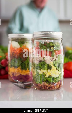 Geschichteter Salat im Glas mit Spinat, Bohnen, Käse und Ei Stockfoto