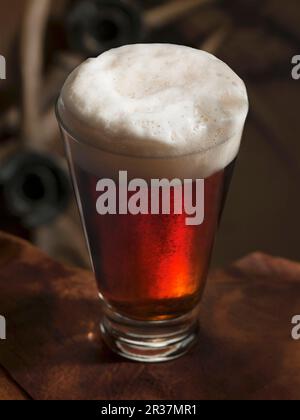 Ein Glas dunkles Bier mit Schaum Stockfoto