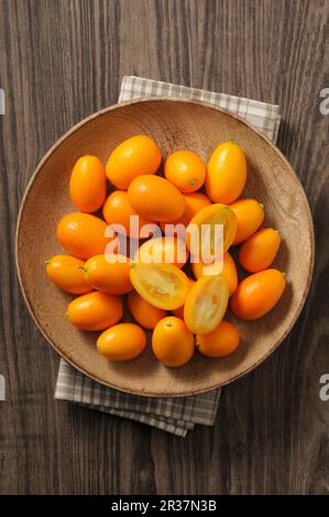 Frische Kumquats in einer Holzschüssel (Draufsicht) Stockfoto