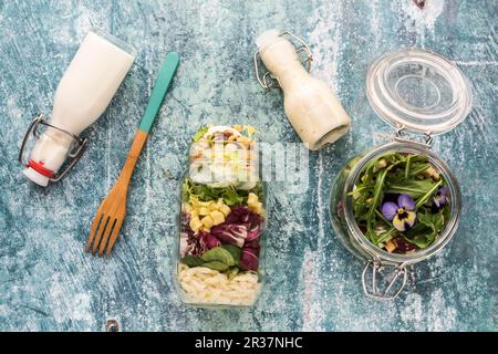 Quinoa und orzo Pasta Salate in Gläsern, mit Ankleideraum und einem hölzernen Gabel Stockfoto