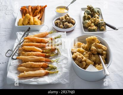 Bierteig Gemüse serviert mit Kroketten und Kartoffel Pommes mit Dip (vegane) Stockfoto