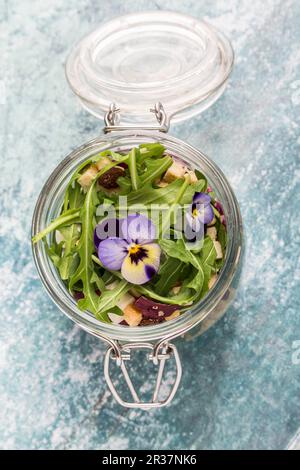 Quinoa Salat mit lämmer Eisbergsalat, Radicchio, Rucola, Croutons, Ziegenkäse und gehörnten Veilchen im Glas Stockfoto