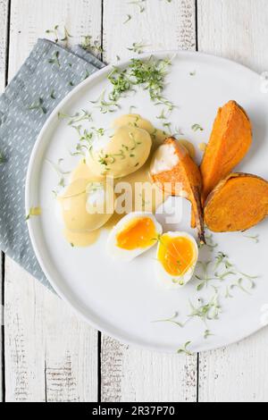 Eier in Senfsauce mit Süßkartoffeln und Kresse Stockfoto