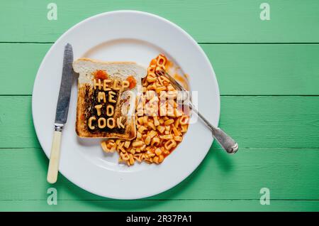 Burnt Toast mit dem Schriftzug "hilf mir zu kochen" in Pasta Formen Stockfoto