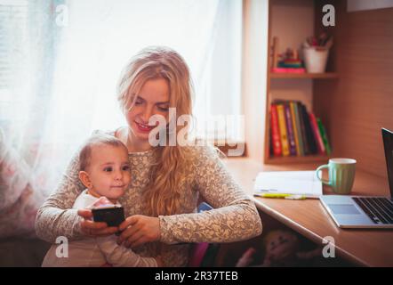 Freiberuflich arbeitete Mama mit baby Stockfoto