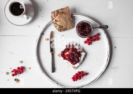 Brot und Marmelade auf einem weißen Holzbrett mit einer Tasse Kaffee (von oben gesehen) Stockfoto