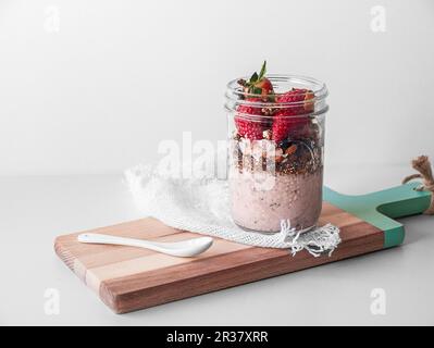 Ein veganes Frühstück in einem Glas mit Joghurt, Müsli und Erdbeeren Stockfoto