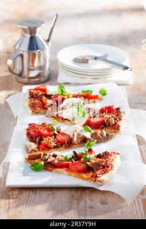 Scheiben Pizza mit Kirschtomaten und Thunfisch Stockfoto