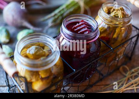 Eingelegtes Gemüse in Gläsern (rosenkohl, Rote Bete, Spargel) Stockfoto