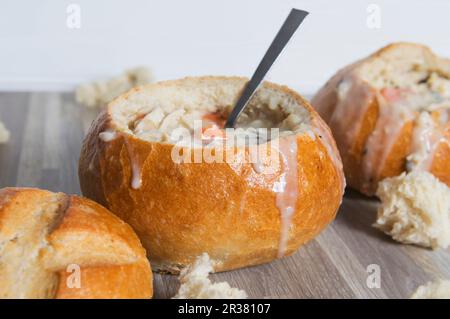 Cremige Hühnersuppe mit wildem Reis, serviert in ausgehöhlten Brötchen Stockfoto