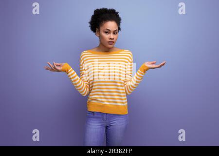 Porträt einer jungen Latina-Modelldame mit Afro-Locken im Studiohintergrund Stockfoto