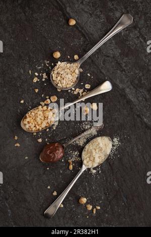 Klassische Löffel mit Hafer, gehackten Haselnüssen, gemahlenen Mandeln und Nutella-Schokoladenaufstrich Stockfoto