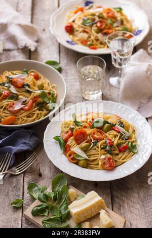 Spaghetti mit Kirschtomaten, frischem Basilikum, Oliven, Chili und Parmesan Stockfoto