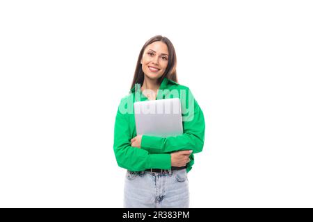 Süße junge, braunäugige, braunhaarige Karrierefrau mit Make-up in einer grünen Bluse arbeitet Remote im IT-Bereich Stockfoto