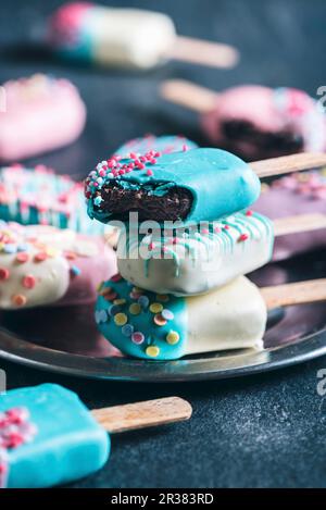 Cake Pops in Form von Eislollies mit farbenfrohen Glasuren (Nahaufnahme) Stockfoto