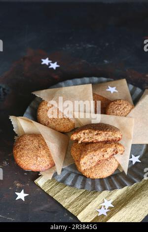 Hausgemachtes Lebkuchen in Pergamenttaschen auf einem Zinnteller, mit Sternen gestreut (glutenfrei) Stockfoto