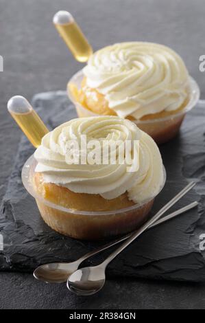 Rum baba mit Sahne in Plastikschüsseln Stockfoto