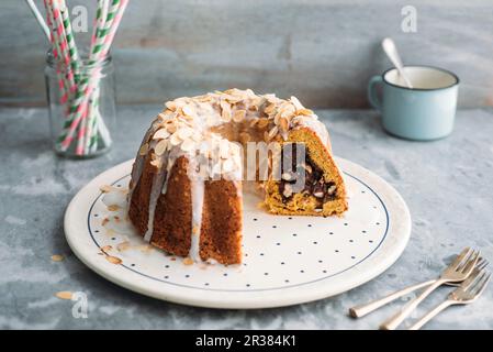 Karotten-Gugelhupf mit frischer Käse-Schokolade-Füllung und Zitronenglasur Stockfoto