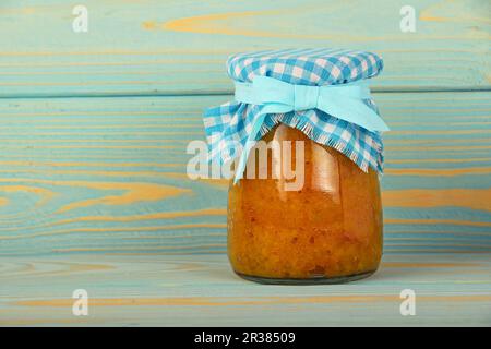 Ein Glas mit Quitte Konfitüre im Blue vintage Holz Oberfläche Stockfoto