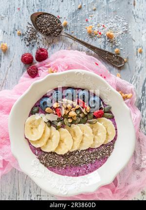 Beeren-Smoothie-Schüssel mit Bananen, Chia, Mandeln und Kürbiskernen Stockfoto