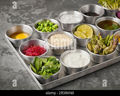 Zutaten für die Herstellung von Quinoa Burger und Muffins in kleinen Schüsseln Stockfoto