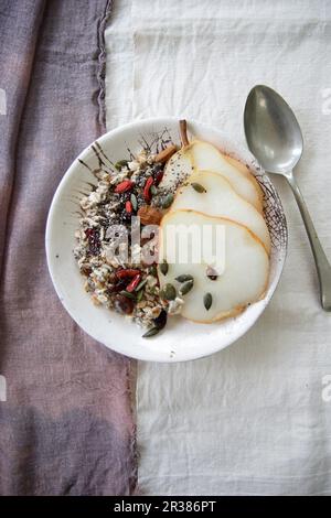 Haferbrei mit Chia, Goji-Beeren und Birnenscheiben Stockfoto