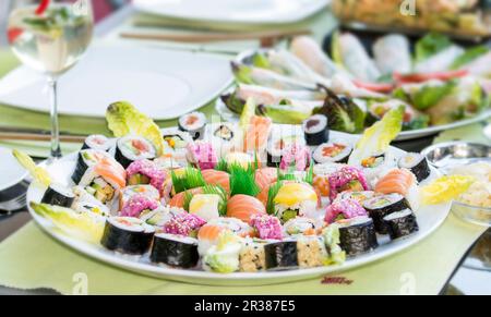 Verschiedene Sushi-Sorten auf einer runden Servierplatte (Japan) Stockfoto