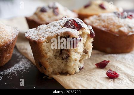 Frisch gebackene Cranberry Muffins auf Pergamentpapier mit Zuckereier Stockfoto