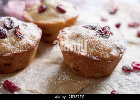 Frisch gebackene Cranberry Muffins auf Pergamentpapier mit Zuckereier Stockfoto