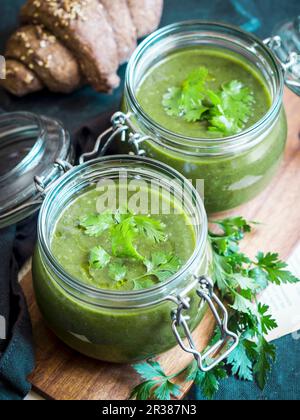 Vegane Creme aus gebackenen Zucchini, Süßkartoffeln und Spinatsuppe, serviert in Einmachgläsern Stockfoto