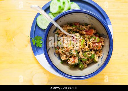 Bulgur-Weizensalat mit Zwiebeln, Tomaten, Minze und Granatapfelsirup Stockfoto