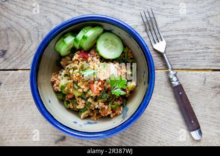 Bulgur-Weizensalat mit Zwiebeln, Tomaten, Minze und Granatapfelsirup Stockfoto