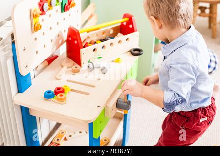 Junge spielt mit Holzspielzeug Stockfoto