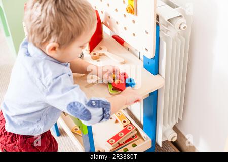 Junge spielt mit Holzspielzeug Stockfoto