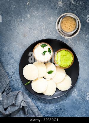 Traditionelles Frühstück mit Idli (Reiskuchen), Koriander-Chutney, Kokosnuss-Chutney und Kaffee (Südindien) Stockfoto