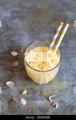Eine Mango in einem Glas mit einem Strohhalm Stockfoto