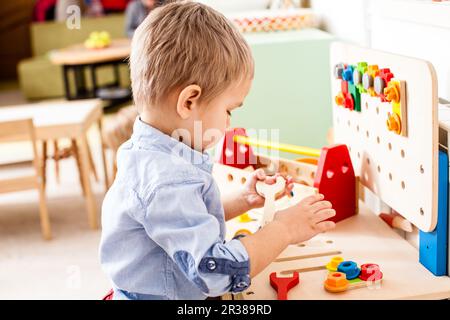 Junge spielt mit Holzspielzeug Stockfoto