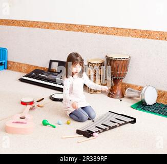 Süße Mädchen spielen auf dem Xylophon Stockfoto