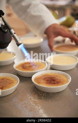 Crème brûlée wird karamellisiert Stockfoto