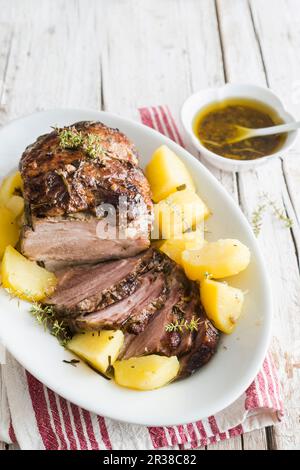 Kronenbraten von Schweinefleisch mit Kartoffeln auf einer Platte Stockfoto