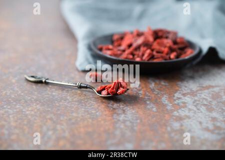 Getrocknete Goji-Beeren in einer Schüssel und auf einem Löffel Stockfoto