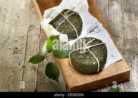 Zwei Pecorino-Käse mit Brennnesselschale auf einem Holzbrett Stockfoto