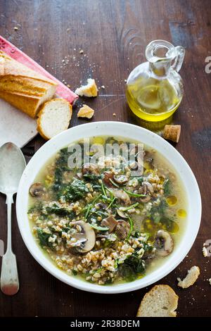 Dinkelsuppe mit Pilzen und Spinat Stockfoto