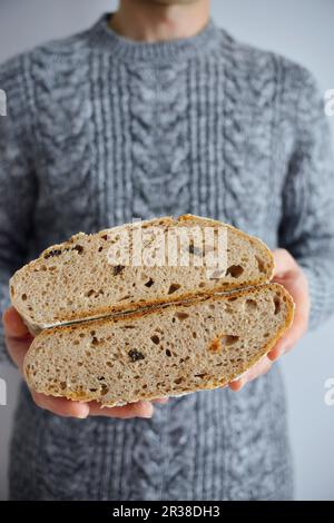 Der Mann hält gebackenes Brot in den Händen Stockfoto